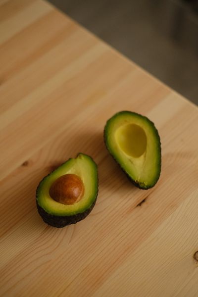 Ripe avocado halves on a wooden table